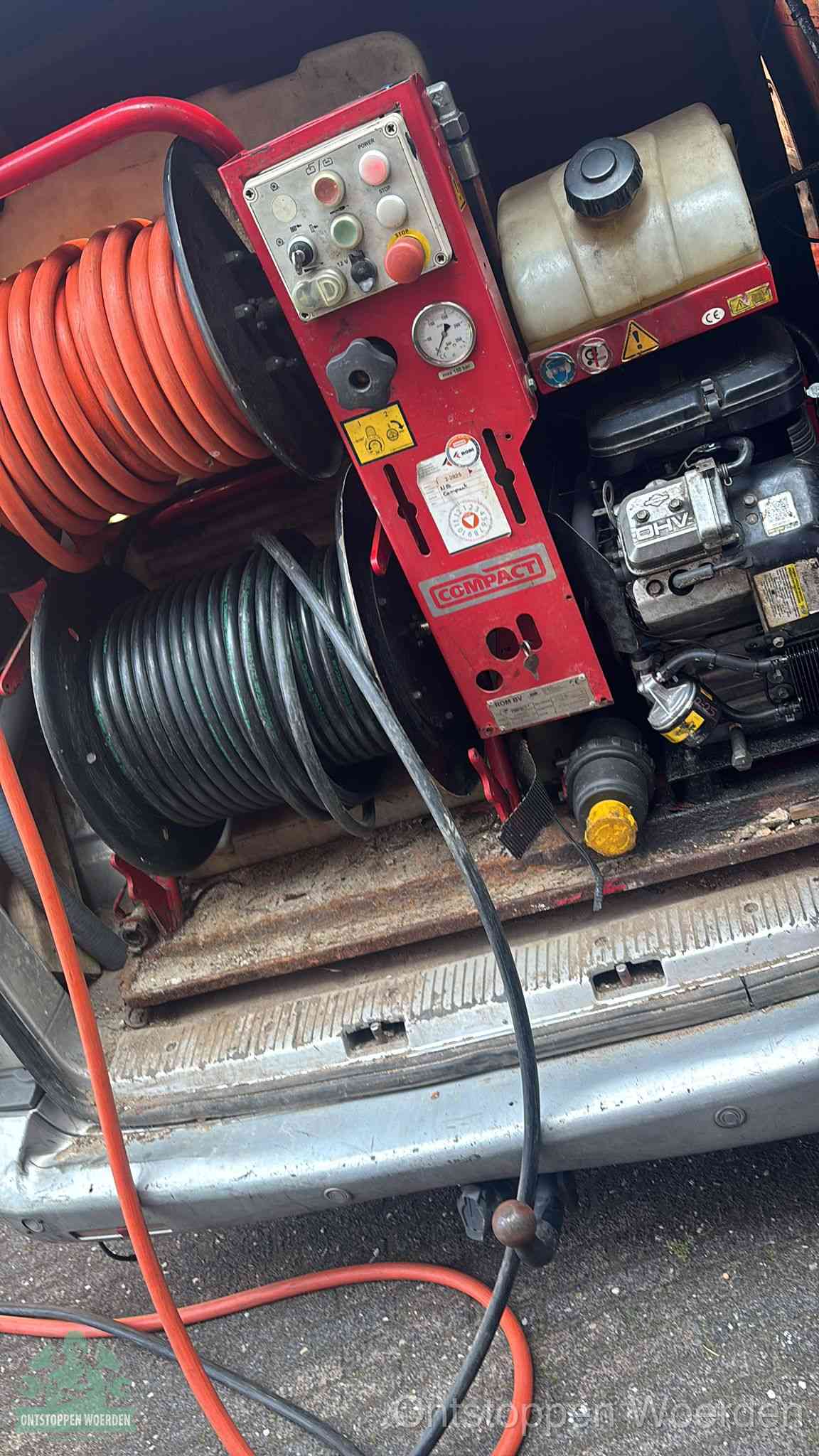 Een rood hogedruk-rioolreinigingstoestel in de laadbak van de bedrijfsbus, apparatuur voor een hardnekkige afvoerverstopping in Woerden