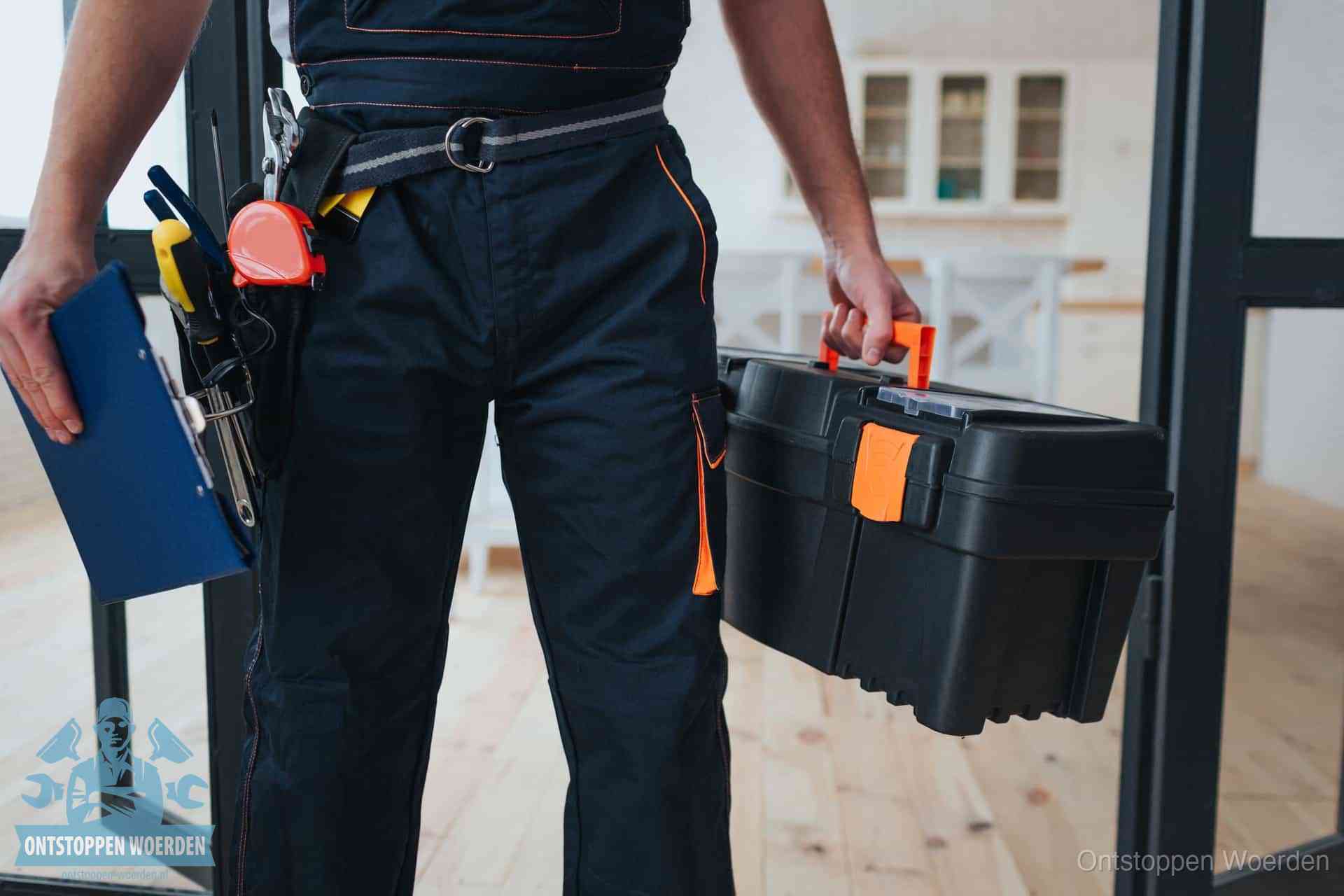 Een monteur met gereedschapsriem en klembord in een keuken, klaar om een transparante prijs voor het gootsteen ontstoppen in Woerden te geven