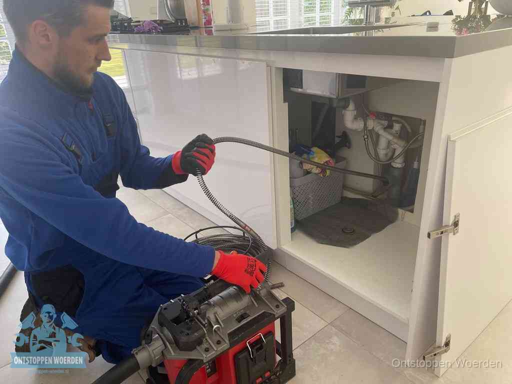 Een monteur reinigt de keukenafvoer grondig met een veermachine om terugkerende gootsteenverstoppingen te voorkomen in Woerden